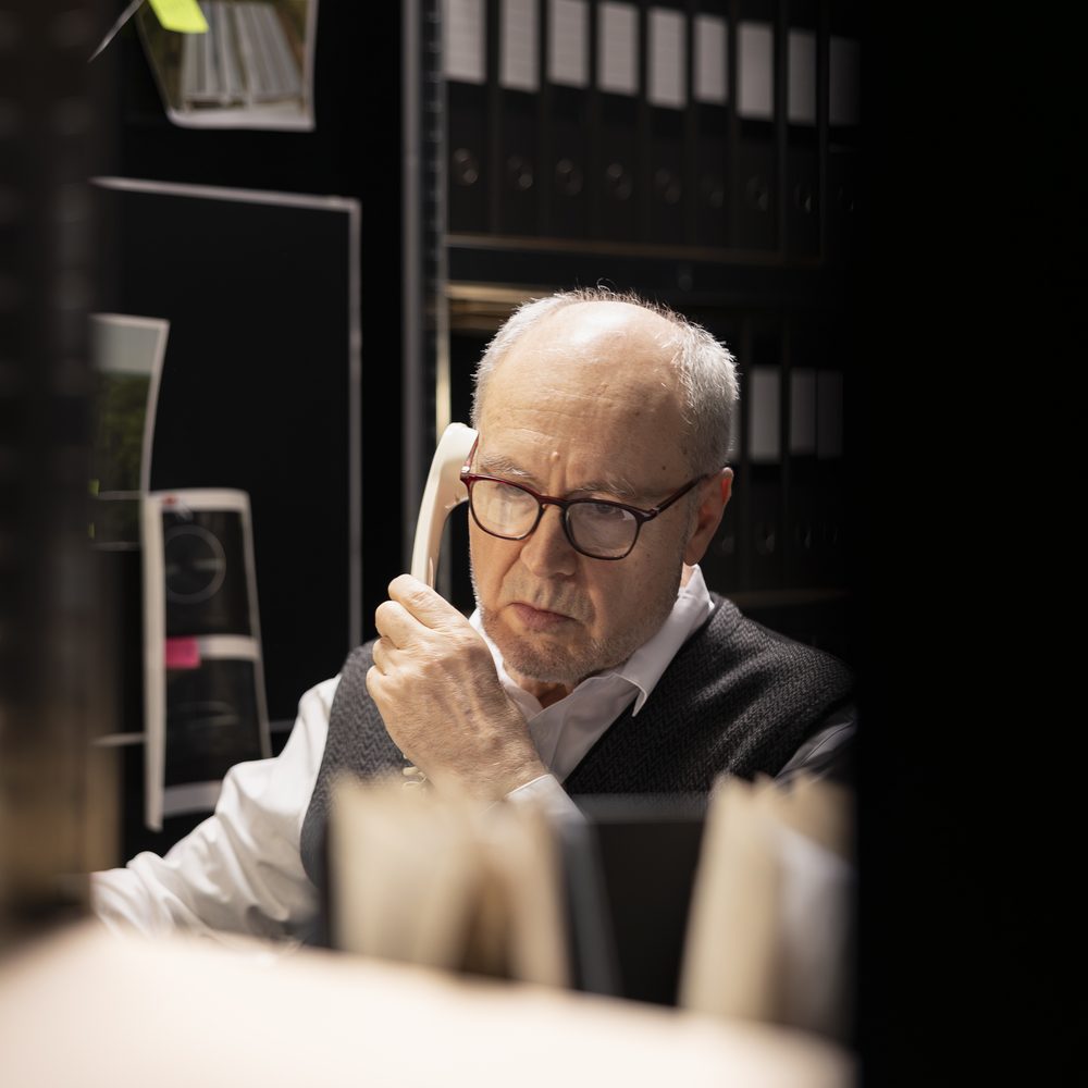 Senior inspector verifying information for a criminal case with landline phone, using the forensic department for important clues and cross checking evidence. Connections for organized crime.